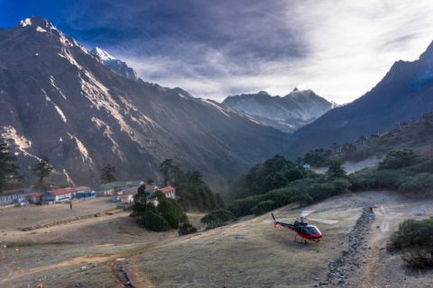Helicopter landing in remote Himalayan village surrounded by mountains in Nepal, Day Everest Heli Trek